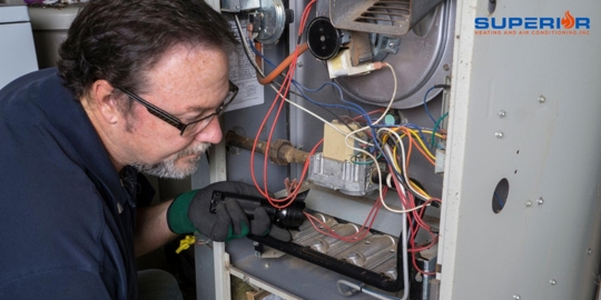 A service technician inspects a gas furnace