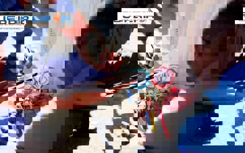 Two technicians service an AC unit